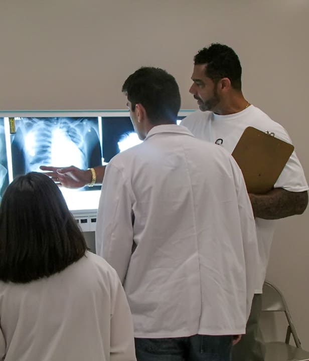 Students gather around an x-ray machine to review a scan