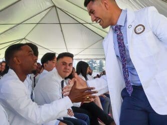 students shake hands during white coat ceremony