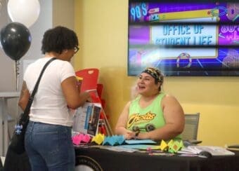 Student visits Office of 90s-themes Student Life booth at the 2024 Resource Fair